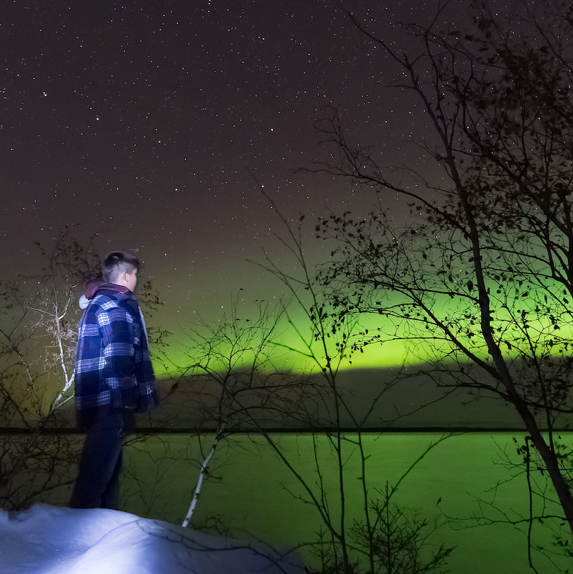 Young person looking at northern lights